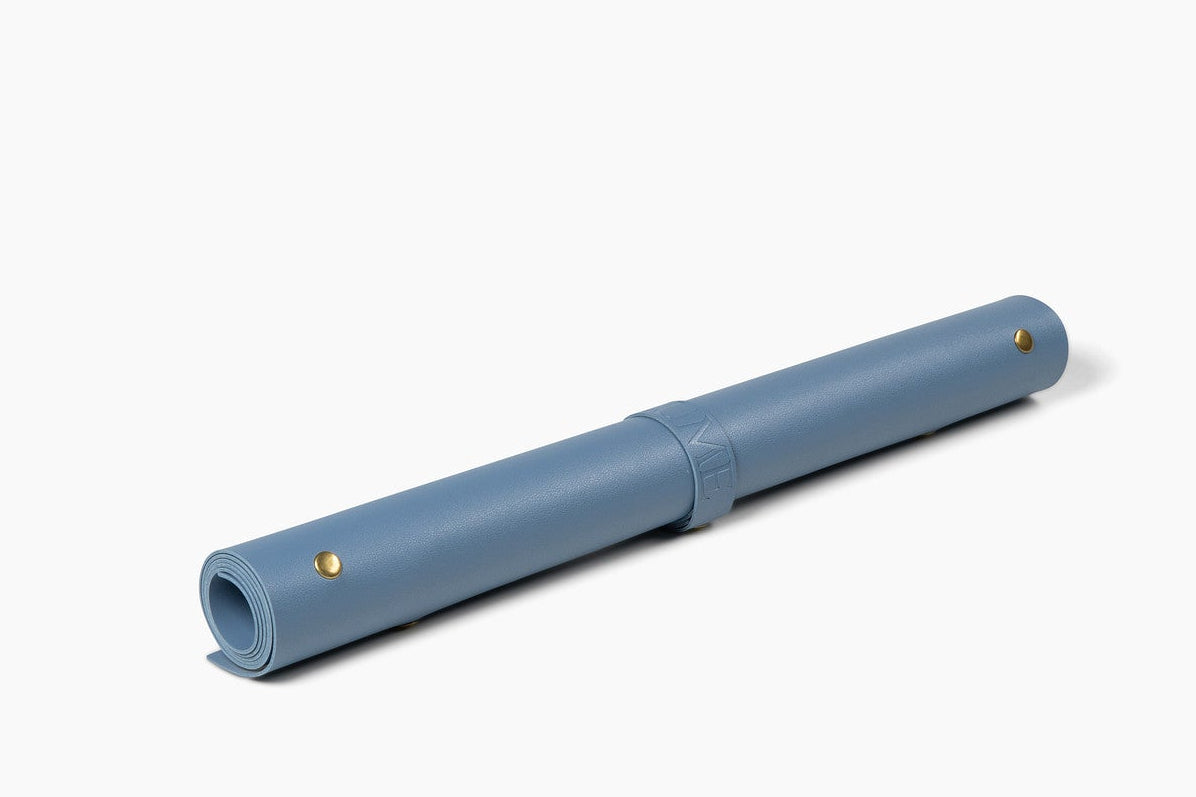 Blue leather potting mat rolled up on white background