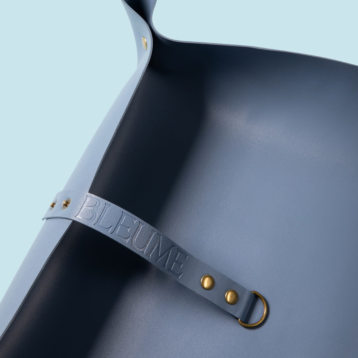 Leather strap embossed with the word Bleume on a blue background